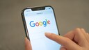 Person nutzt Google auf einem Smartphone.