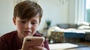 Kind surft auf dem Smartphone im Internet