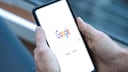 Person hält ein Smartphone mit geöffneter Google-Suche in Händen.