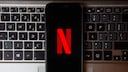 Netflix Titelverlauf: Handy mit totem N-Logo auf Laptop-Tastatur