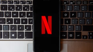 Netflix Titelverlauf: Handy mit totem N-Logo auf Laptop-Tastatur