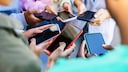Viele Smartphones in der Hand von Menschen