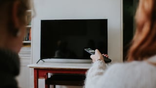 Symbolbild: Frau versetzt Fernseher in Standby-Modus.