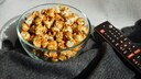 Streaming Kosten: Popcorn neben Fernbedienung
