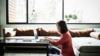 WLAN-Reichweite: Frau mit Laptop im Wohnzimmer