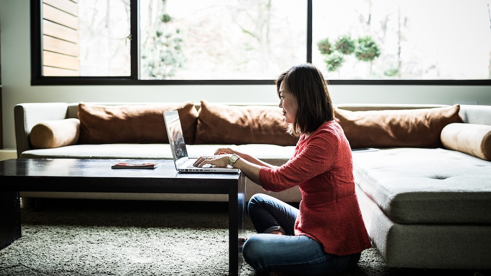 WLAN-Reichweite: Frau mit Laptop im Wohnzimmer