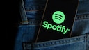 Spotify-Logo auf einem Handy, das in einer Hosentasche steckt.