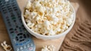 Eine Schüssel Popcorn neben einer TV-Fernbedienung