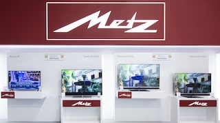Das Metz-Logo an einem Messestand mit mehreren Fernsehern