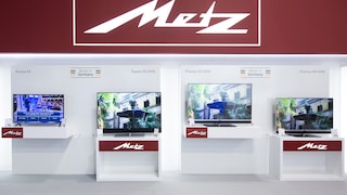 Das Metz-Logo an einem Messestand mit mehreren Fernsehern