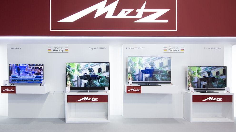 Das Metz-Logo an einem Messestand mit mehreren Fernsehern