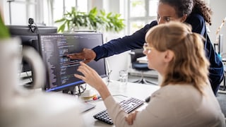 Zwei Frauen am PC mit Code vor sich vielleicht von Passwortmanagern