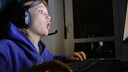 Junge sieht mit aufgerissenen Augen am Computer