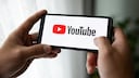Person hält Smartphone mit YouTube in den Händen