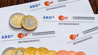 Rundfunkbeitrag-Zettel mit Euromünzen