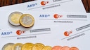 Rundfunkbeitrag-Zettel mit Euromünzen