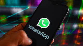 Person hält Smartphone mit WhatsApp auf dem Display in der Hand