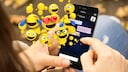 Person schaut auf ein Smartphone, über dem lauter Emojis schweben