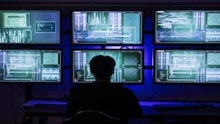 Person sitzt vor mehreren Monitoren