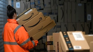 Person trägt mehrere Pakete von Amazon