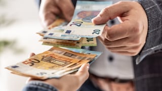 Personen händigen einander Geld aus