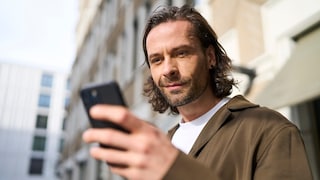 Mann schaut auf sein Handy