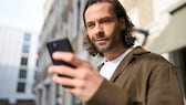 Mann schaut auf sein Handy