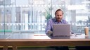 Mann nutzt einen PC von Microsoft – keinen Mac