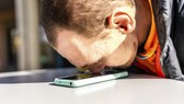 Mann hält seine Nase auf sein Smartphone