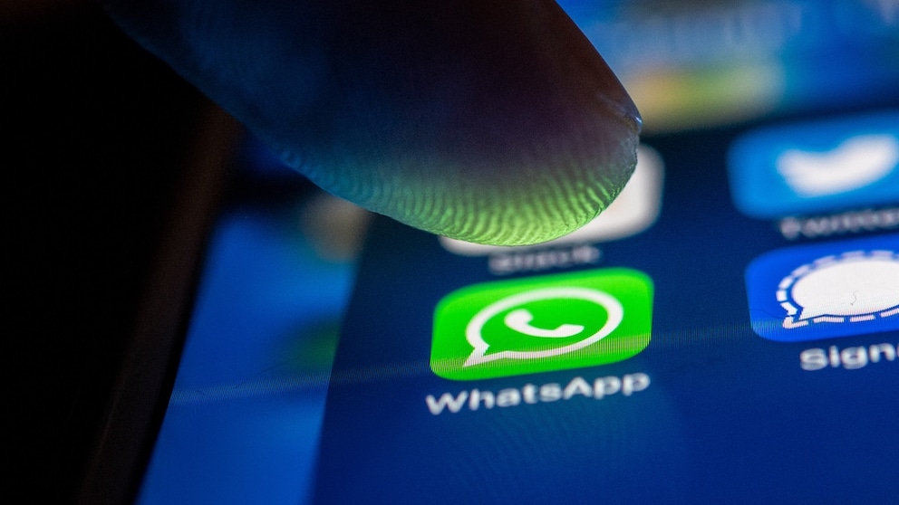 Person drückt mit dem Finger auf WhatsApp auf dem Smartphone