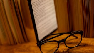 E-Book-Reader steht zwischen Büchern auf einem Tisch