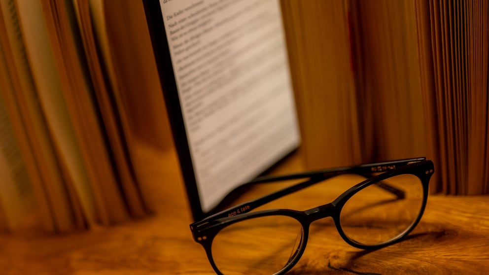 E-Book-Reader steht zwischen Büchern auf einem Tisch