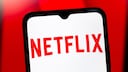 Netflix Logo auf einem Smartphone mit rotem Hintergrund