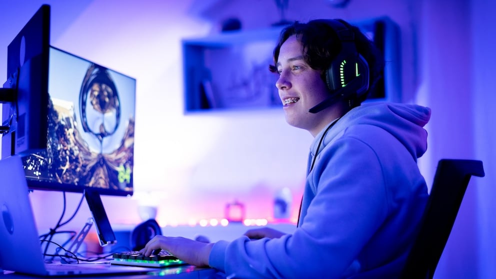 Junger Mann sitzt vor dem Rechner und streamt live