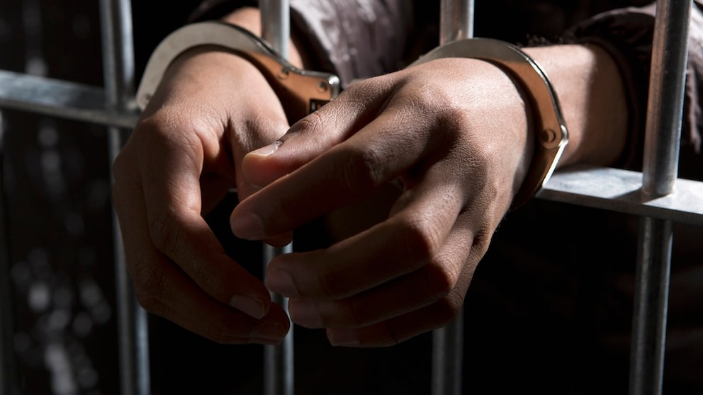 Person mit Handschellen im Gefängnis