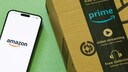 Amazon Paket und ein Smartphone daneben mit Amazon-Logo