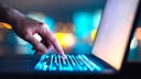 Person tippt auf eine Laptop-Tastatur