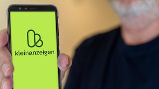 Mann hält Smartphone in der Hand, das Kleinanzeigen-Logeo ist zu sehen
