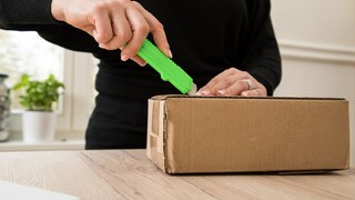Frau öffnet ein Paket