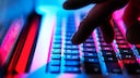 Person tippt auf einem Laptop