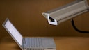 Überwachungskamera ist auf einen aufgeklappten Laptop gerichtet