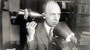 Mann telefoniert mit einem von Alexander Graham Bell entwickelten Telefonapparat
