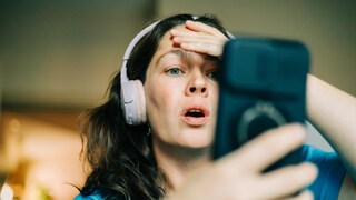 Schockierte Frau am Smartphone