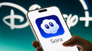 Smartphone mit Sora Logo und Disney Logo im Hintergrund