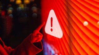 Finger der auf Bildschirm mit rotem Warnzeichen zeigt