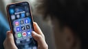 Teenager mit Smartphone und Social Media Apps in der Hand