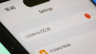 Smartphone mit iOS 26 Update Text