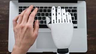 Roboter Hand und menschliche Hand die auf Computer tippen