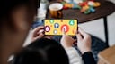Kind und Elternteil die am Smartphone spielen