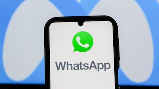 Smartphone mit WhatsApp Logo und Meta Logo im Hintergrund